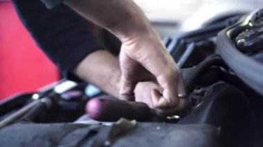 Eski bir arabanın motorunu tamir eden oto tamircisi