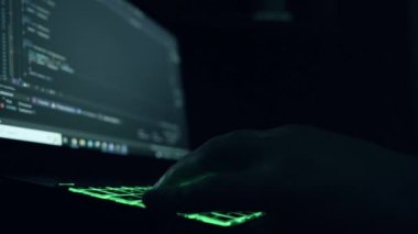 Erkek programcı bir dizüstü bilgisayara program kodu yazar. Yakın plan. gece