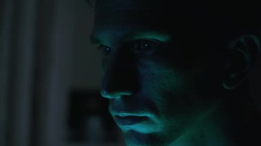Portrait of a male hacker. nervous look. close-up. green