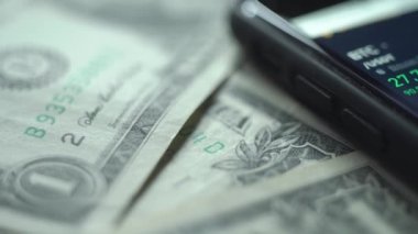 Akıllı telefondaki kripto para piyasasının gerçek zamanlı analizi. Dolar banknotları. yakın plan
