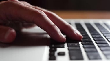 Genç bir adam dizüstü bilgisayarın klavyesine dokunup bir fikir bulmaya çalışıyor.