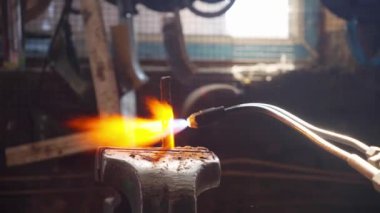 Erkek bir zanaatkar gaz lambası kullanır. atölye