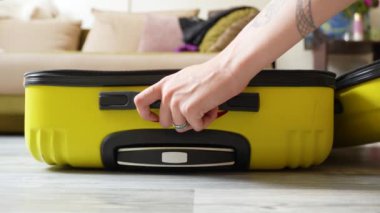 Tatil için bavul hazırlayan genç bir kadın.