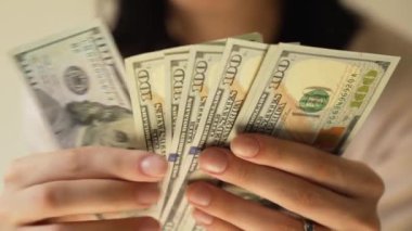 Kadınların elleri dolarları sayıyor. Yakın plan.