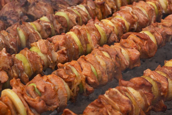 stock image Pieces of meat and onion threaded on metal skewers and grilled over hot coals. Shashlicks. Picnic food