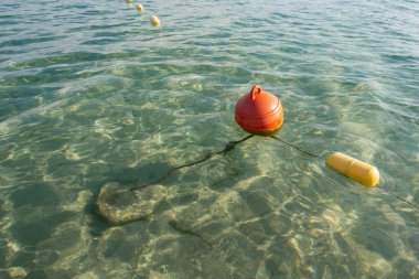 Durgun göle demirlenmiş kırmızı şamandıra. Su kurtarma ekipmanları. Güvenli su.
