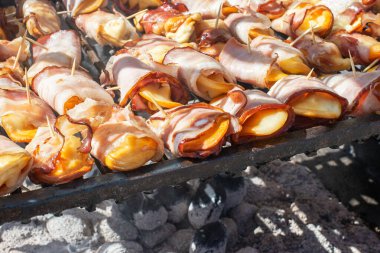 Smoked ewe's milk cheese with bacon grilled on charcoal during the street food festival. Polish traditional food