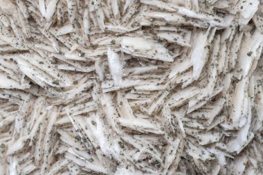 Small cube-shaped crystals of pyrite on milk-white barite. Natural minerals as background