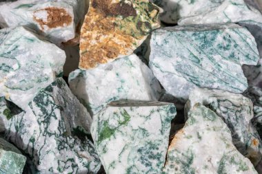 Heap of unpolished moss agate mineral rocks