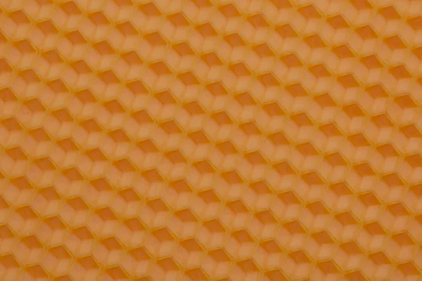 オレンジ色の紙に隔離された六角形の蜜蝋基礎シート ハニカムテクスチャ — ストック写真