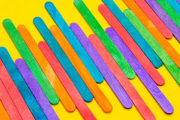 Gekleurde Ijslolly Sticks Naast Elkaar Geplaatst Houten Ijsstokjes Geel Papier Rechtenvrije Stockafbeeldingen