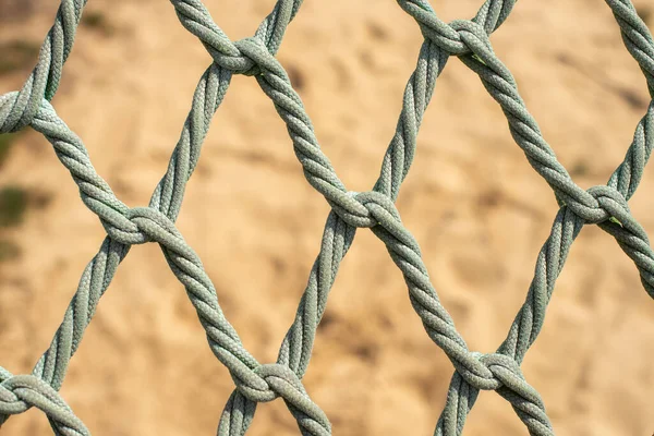 stock image Playground safety net over a sandy background. Knotless Rope. Braided rope