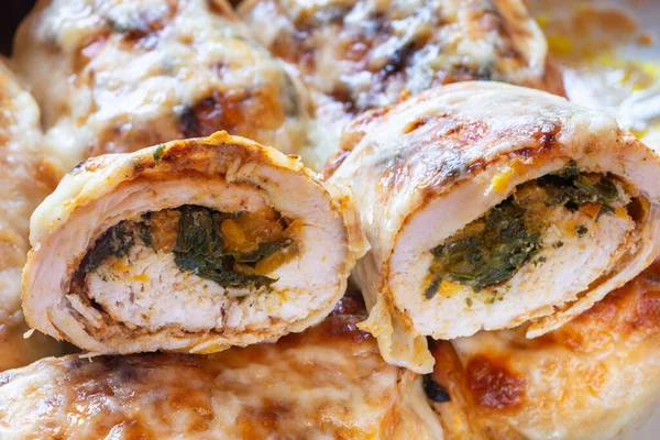 Halves of chicken rolls stuffed with spinach and carrot, cross section