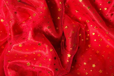 Kırmızı şifon kumaş dokusu. Lüks doğum günü geçmişi. Noel ve yeni yıl süslemeleri. Altın yıldızlar