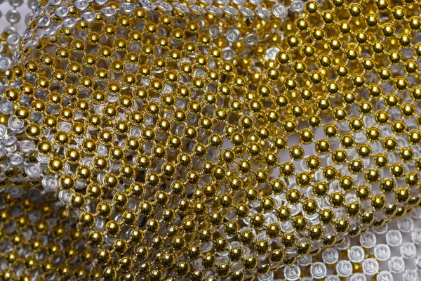Flexible decorative tape made of string connected beads in golden color. Christmas craft making
