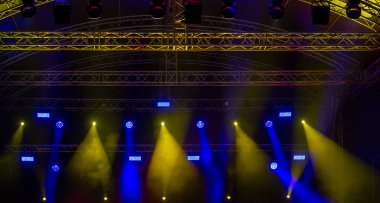 Sarı ve mavi tonlarda ışık huzmeleri. Açık havada sahne ışıkları