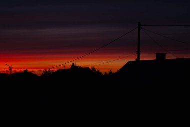 Kırsal çatı siluetleri gün batımında