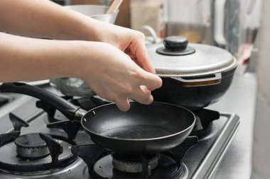 Yumurtayı küçük bir tavada kızartıp tipik bir Kolombiya kahvaltısı hazırlayan bir kadının eli..