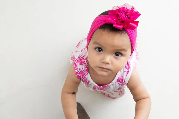 地面に美しい茶色の肌の赤ちゃんの女の子のゼニスショットを見上げます 白い背景 — ストック写真