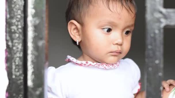 Melihat Seorang Bayi Perempuan Latin Melihat Luar Jendela Dengan Wajah — Stok Video