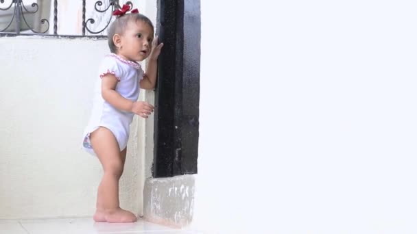 Beautiful Brown Skinned Latina Baby Learning Walk Holding Door Looking — Video Stock