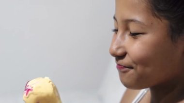 close-up of a little girl, brunette latina very happy licking her ice cream cone
