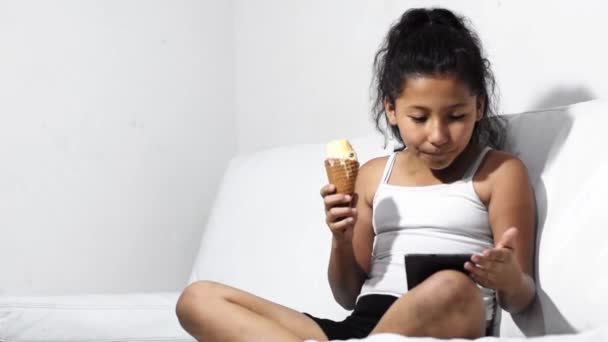 Brunette Latina Girl Eating Ice Cream Looking Her Tablet Amazed — Video