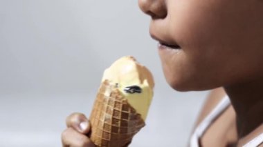 detailed shot of a brunette girl's mouth licking an ice cream, with a white background