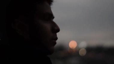 panoramic scan of a teenager's face looking out over the city at night.