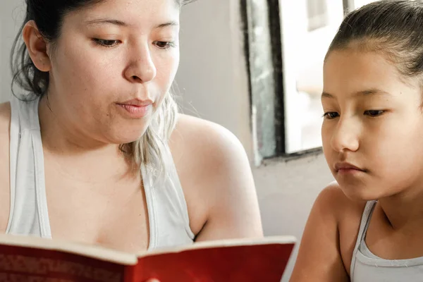 detailed close-up of a mother's face reading a book to her young daughter
