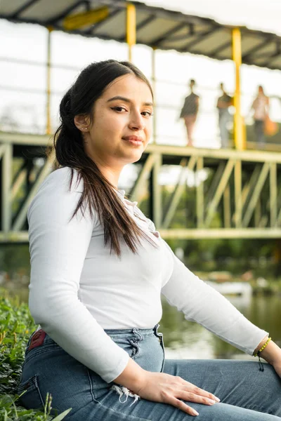 Junge Lateinische Frau Sitzt Einem See Neben Einer Brücke — Stockfoto