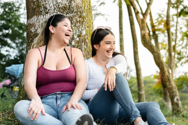 Two Friends Sitting Next Tree Laughing Loudly While Looking Side — Stock Photo, Image