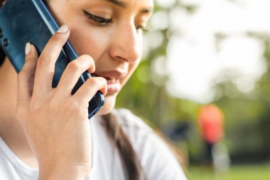 Cep telefonuyla konuşan genç bir kadının detaylı görüntüsü.