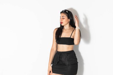 Beyaz arka planda poz veren ve yan bakan güzel kahverengi tenli Latin kadın portresi