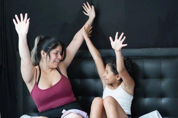 Joven Latina Madre Morena Hija Celebrando Sentado Cama Levantando Las — Foto de Stock