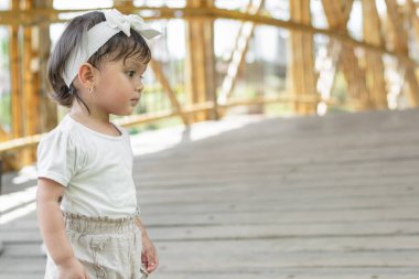 Koyu renk saçlı küçük bir kızın yakın çekimi, çok yoğun ve ciddi bir şekilde bir tarafa bakıyor.