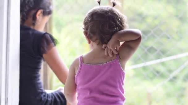 Крупный План Спины Ребенка Латиноамериканца Смотрящего Сестру Царапающего Спину Рукой — стоковое видео