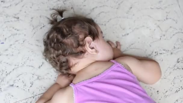 바닥에 누워있는 아기의 아래로 탄트럼을 던지고 — 비디오