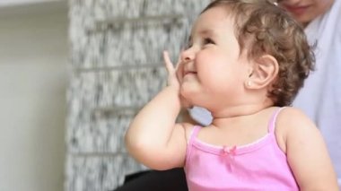 Küçük Latin bebek ağladıktan sonra yüzüne dokunuyor, yanaklarında gözyaşlarıyla.