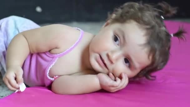 Mooie Latina Baby Liggend Een Roze Speelmat Spelen Met Tag — Stockvideo