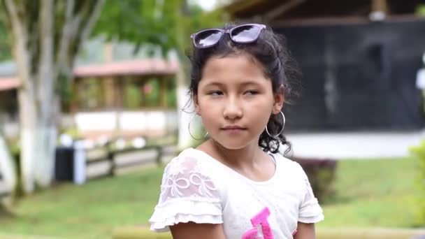 Latina Brunette Meisje Zitten Een Park Rond Kijken Terwijl Glimlachen — Stockvideo