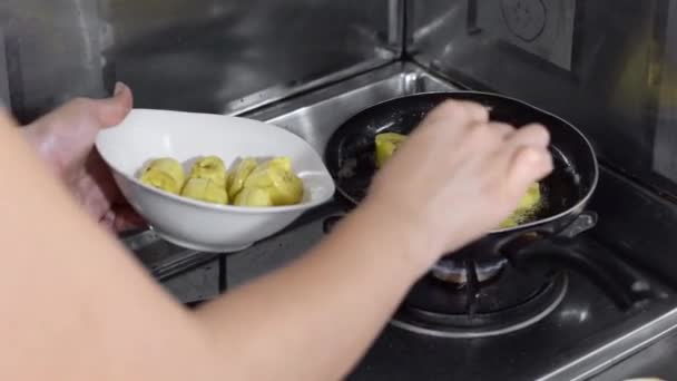 一个女人的手用勺子把油炸的大锅里的油煎出来的特写镜头 — 图库视频影像