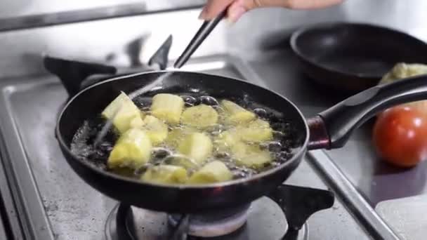 用叉子搅拌妇女的手的特写用菜油在油锅里煎的香蕉片 — 图库视频影像