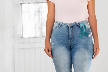 Bir kadının beline, rahim ağzı kanserinin sembolü olan yeşil kurdele takmış..