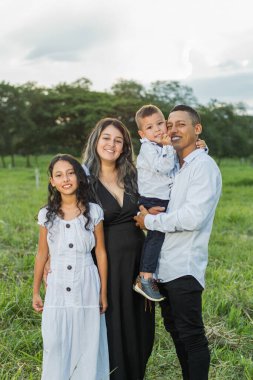 Dört Latin 'in ailesi bir tarlanın ortasında birlikte poz veriyorlar.