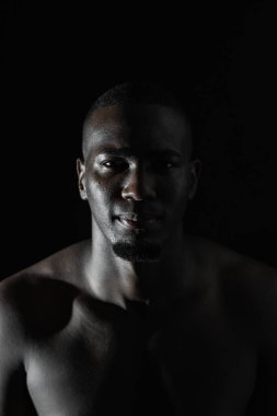 Siyah arka planda 90 derecelik aydınlatmayla Afro-Amerikalı bir adamın yüzüne yakın çekim.