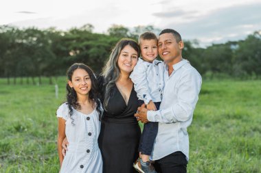 Latin ailesi, birlikte mutlu bir şekilde poz vererek kırsalda dolaşırlar..