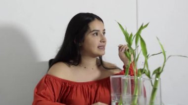 Açıklamak ve tanıklık etmek için ellerini oynatırken saçından bahseden Latin bir kadın.