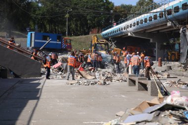 DNIPRO, UKRAINE - 08.24.20: bir Rus roketi Dnipro otobüs durağına çarptı. Otobüs durağı, dükkanlar ve ticaret kulübeleri yıkıldı. İşçiler hasarı temizler