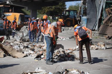 DNIPRO, UKRAINE - 08.24.20: bir Rus roketi Dnipro otobüs durağına çarptı. Otobüs durağı, dükkanlar ve ticaret kulübeleri yıkıldı. İşçiler hasarı temizler